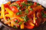 Stewed peppers with tomatoes and onions close up horizontal